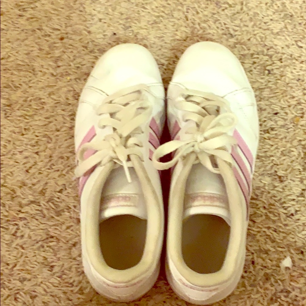 A pair of Addias white shoes with pink stripes